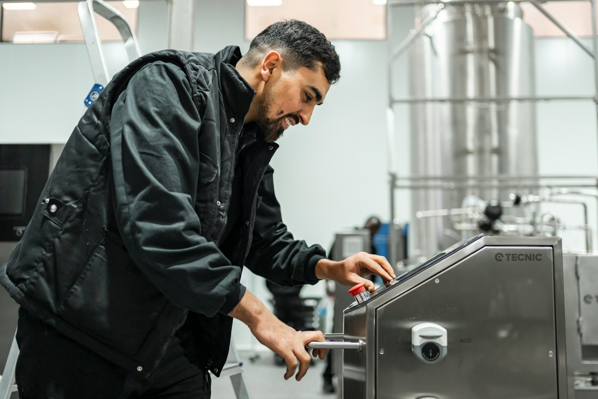 Industrial technician wearing personal protective equipment while working with electrical equipment on site