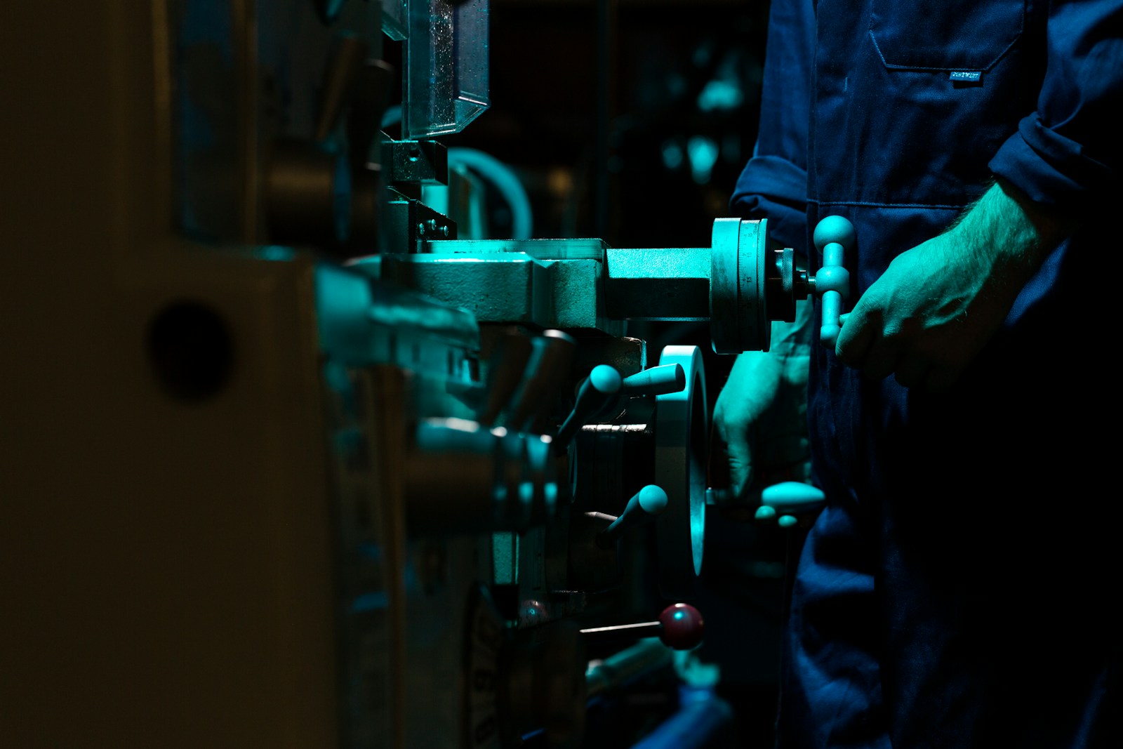 Industrial production machinery on a factory floor with an engineer in attendance